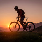 Silhouette of a male mountainbiker at sunset in the mountains