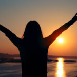 Hopeful Woman Looking at the Sunset by the Sea