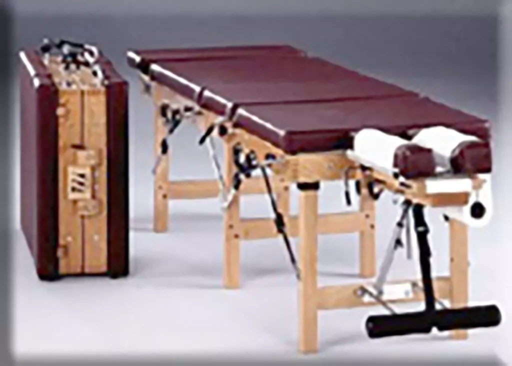 Tragbare, zusammenklappbare Behandlungsliege mit braunem Polster und Holzgestell für Chiropraktiker und Naturheilverfahren.